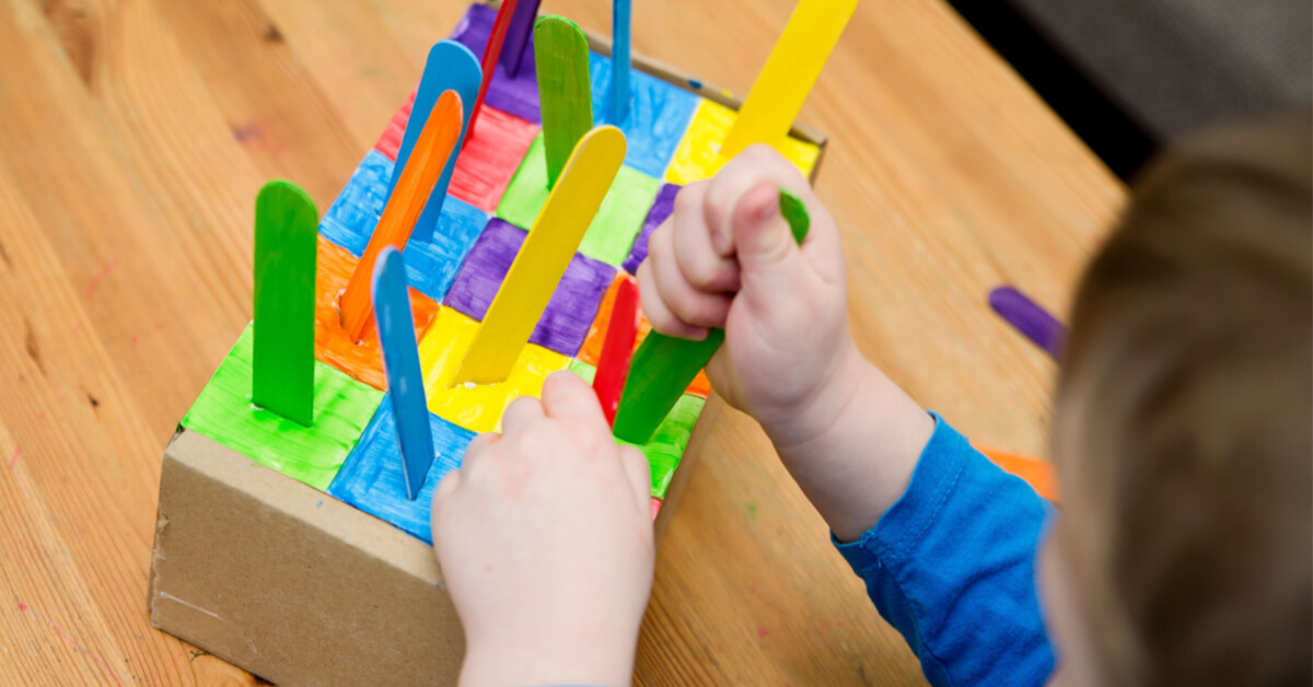 Montessori implement. Sorting by the colors. DIY at home from cardboard box and ice-cream sticks. Easy 5 minute craft. Early preshool eduaction for toddlers.